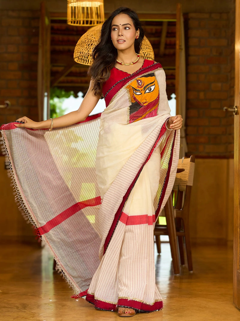 Striking white cotton saree with bold red-black borders, featuring a hand-painted Durga motif with Stitched Blouse