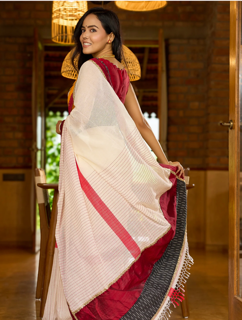 Striking white cotton saree with bold red-black borders, featuring a hand-painted Durga motif with Stitched Blouse